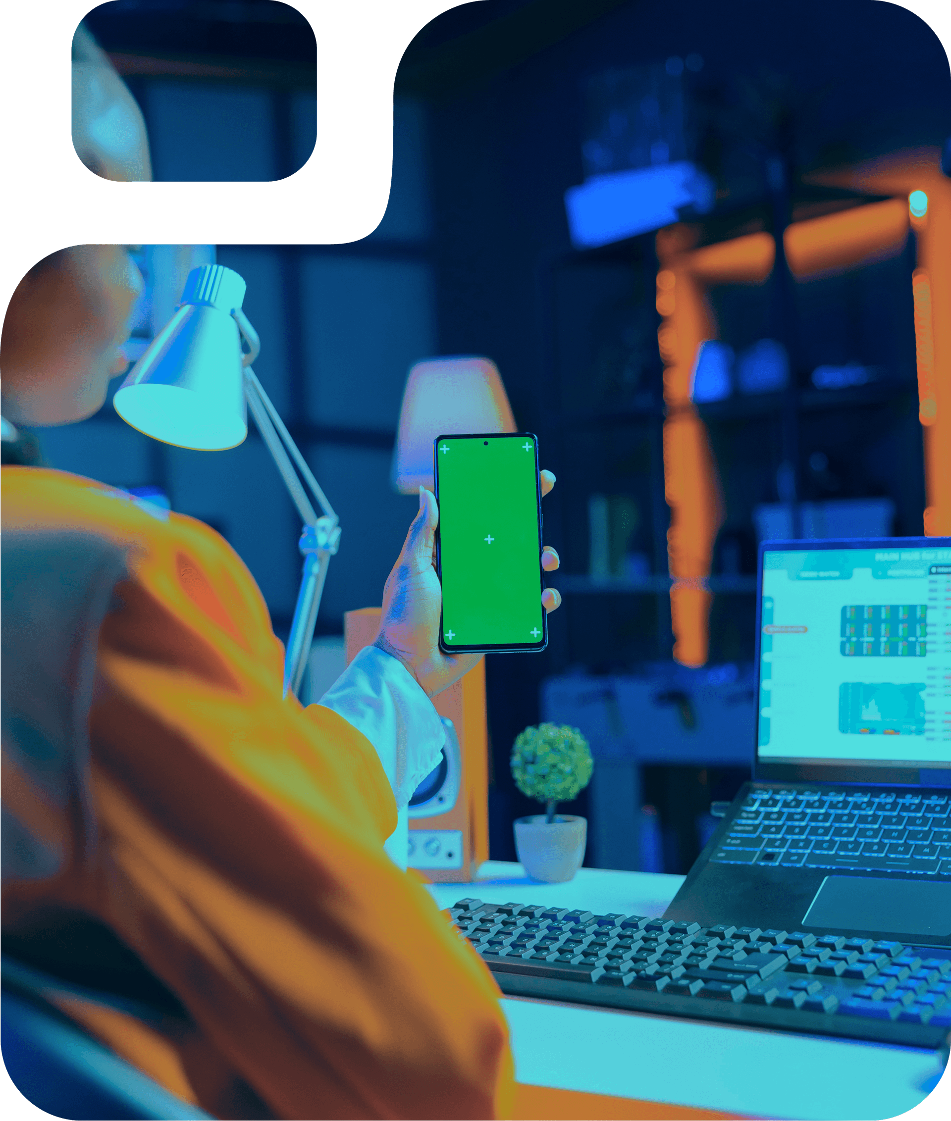 Person with smartphone and laptop, modern workspace